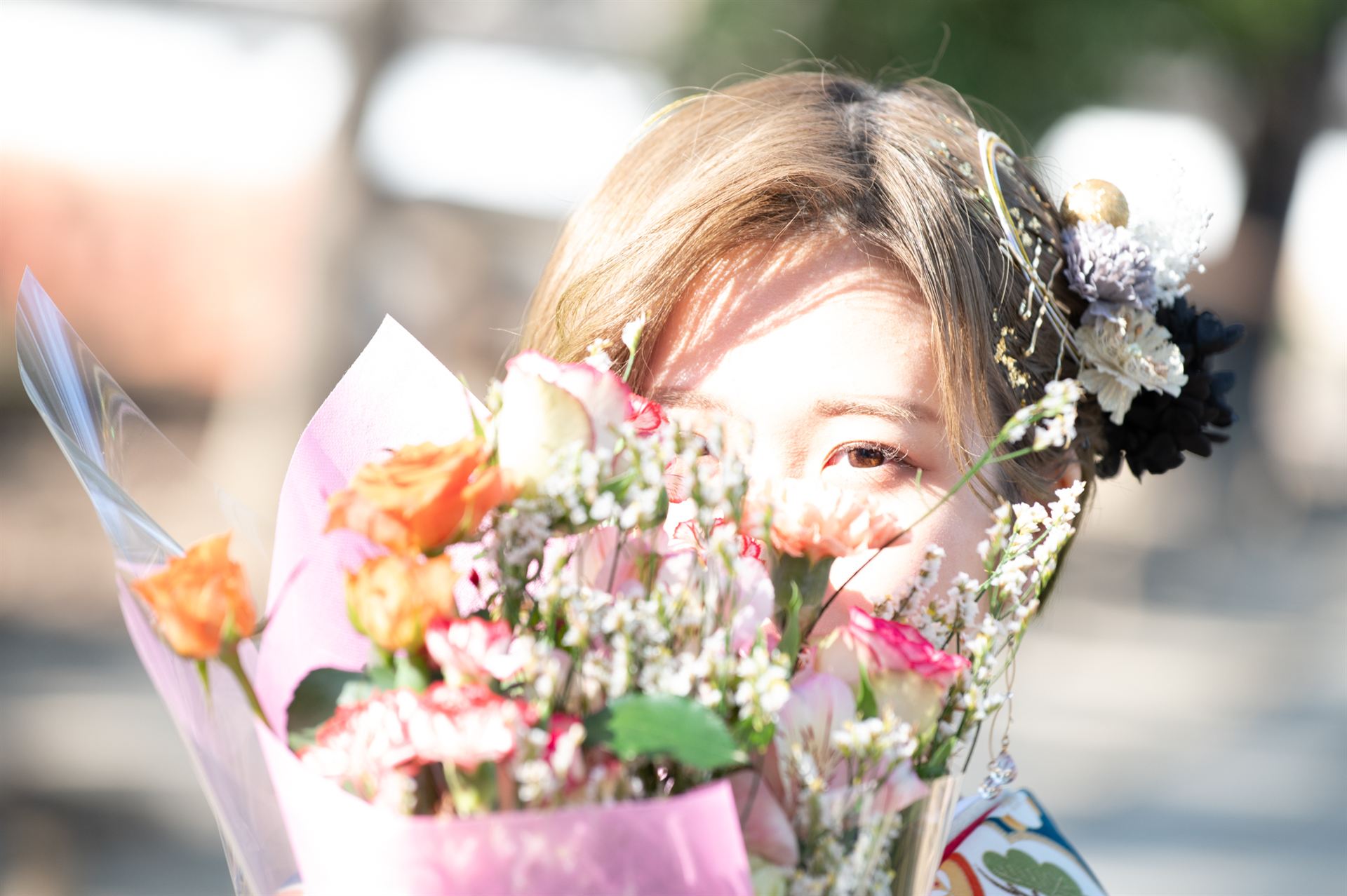 花束越しにほほ笑む振袖姿の女性